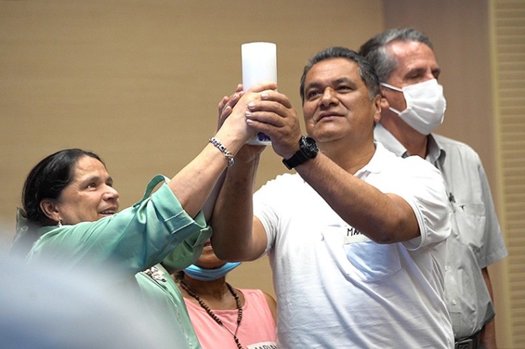 Alba Ceballos, v&iacute;ctima de la Toma  al puesto de Polic&iacute;a, recibe cirio blanco de Mart&iacute;n Cruz Vega, &uacute;ltimo comandante del Frente Aurelio Rodr&iacute;guez, como s&iacute;mbolo de su compromiso con la verdad, la justicia y la no repetici&oacute;n.